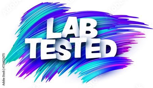 Lab tested paper word sign with blue paint brush strokes over white.