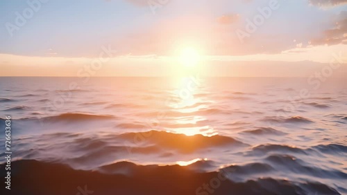The suns gentle glow stretches across the endless ocean creating a soothing streaking effect. photo