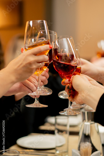 colleagues at work are sitting in a restaurant, celebrating the conclusion of a new agreement toasts with glasses of wine close-up