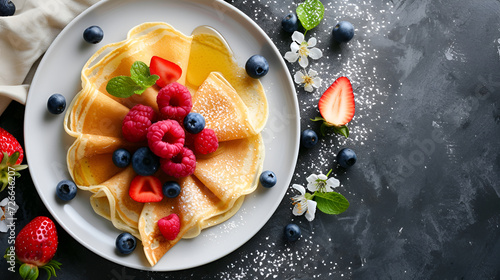 Traditional breakfast homemade thin pancakes with fresh berries and honey on a dark concrete background, top view with space for text. Maslenitsa concept photo
