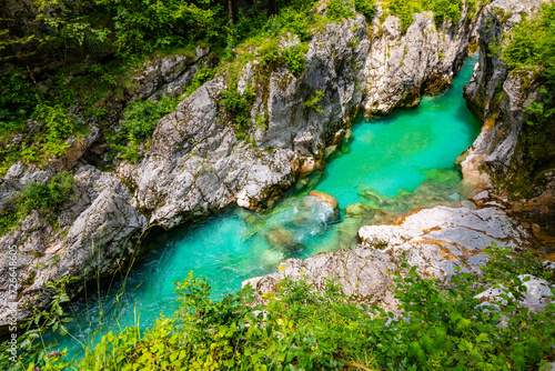 Soča or Isonzo River called Emerald River in Slovenia is a wild alpine river with crystal clear water and typical turquoise green color with many rapids, waterfalls and cascades in a romantic canyon photo