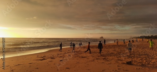 Children playing on the beach at sunset.