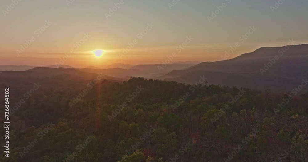 aerial view A beautiful sunrise paints the sky in vivid shades of orange and red over a deciduous forest..Colorful leaves when the season comes to bloom in the big forest..beautiful nature background aerial view A beautiful sunrise paints the sky in vivid shades of orange and red over a deciduous forest..Colorful leaves when the season comes to bloom in the big forest..beautiful nature background