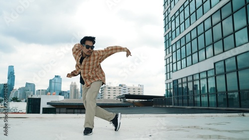 Happy hispanic dancer wears casual outfit break dancing at urban city. Energetic hip-hop performance. Choreographer move along the freestyle beat. Hip hop dancing. Outdoor sport 2024. Endeavor.