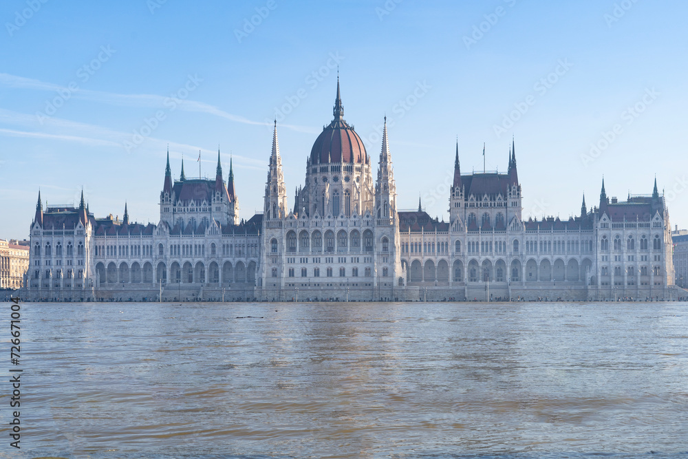 Fototapeta premium The neo-Gothic building of the Hungarian legislature, the Parliament with the river Danube flooding the quays in the foreground