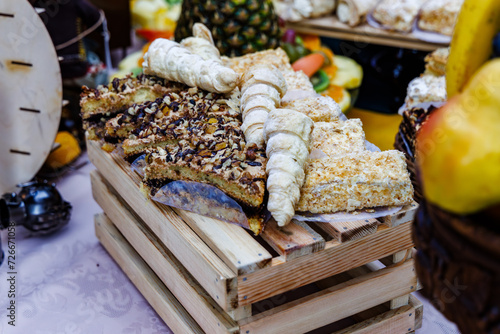 Obraz na płótnie Buffet with a variety of delicious cakes with cream, nuts and served on wooden decorative box w salonie