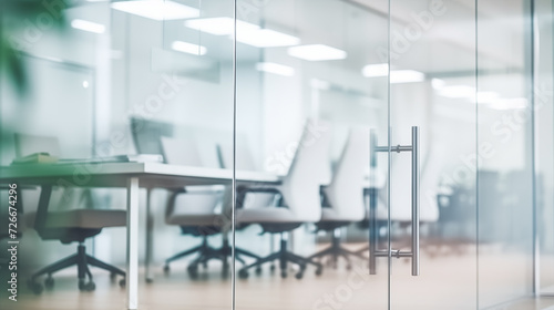 Beautiful blurred background of a modern office interior in gray tones behind glass door © IBEX.Media
