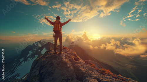 Mountain Triumph at Sunset: A man stands victorious atop a rocky peak, surrounded by the breathtaking beauty of nature, as the sun sets and the sky glows with warm hues, symbolizing success, freedom photo