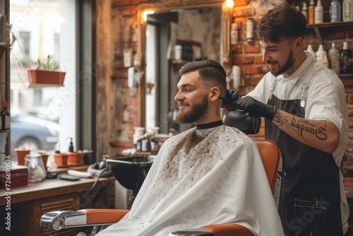 A man sits in a barber shop, his face framed by the white walls as a woman cuts his hair, preparing him for his wedding day with precise and delicate strokes