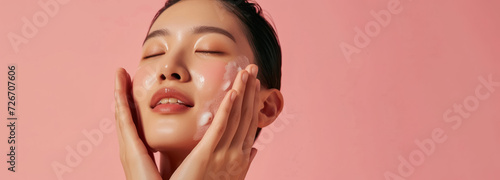 refreshing skincare regime with woman enjoying facial product on rosy background with large  copy space   photo