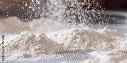 Sifting Flour Through a Fine Mesh Sieve. Close-up of flour being sifted through a metal sieve, capturing the motion of baking preparation.