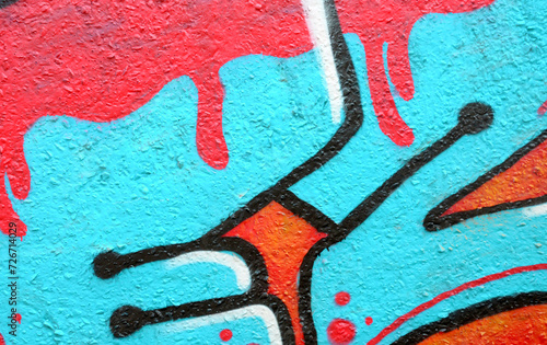 Colorful background of graffiti painting artwork with bright aerosol outlines on wall. Old school street art piece made with aerosol spray paint cans. Contemporary youth culture backdrop