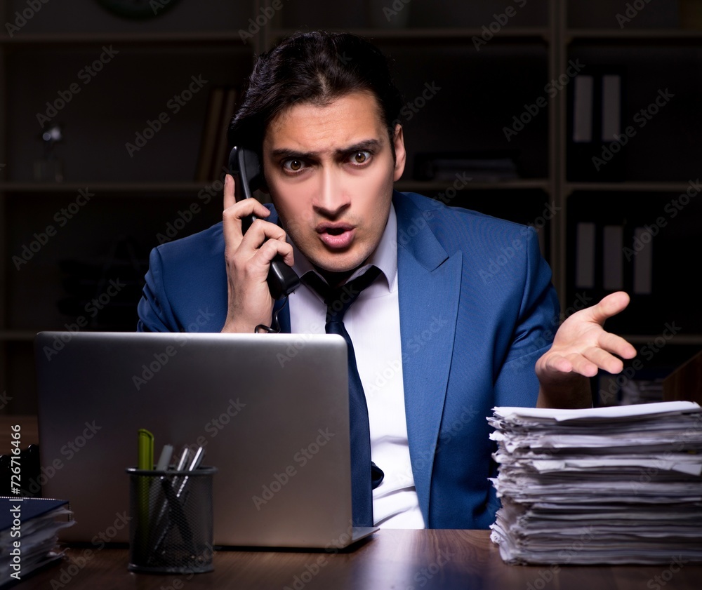 Young male employee working night in the office Young male employee working night in the office