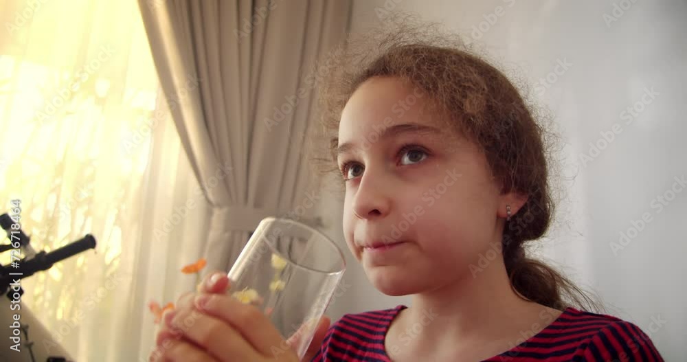 Cute Child Girl Drinking Glass Fresh Transparent Pure Filtered Mineral Water at Home. Slow Motion Little Girl Drinks Water. Closeup Kid drinking Cup Water Healthy Body Care. Healthy lifestyle Children Cute Child Girl Drinking Glass Fresh Transparent Pure Filtered Mineral Water at Home. Slow Motion Little Girl Drinks Water. Closeup Kid drinking Cup Water Healthy Body Care. Healthy lifestyle Children