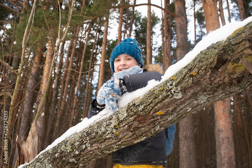 Smiling 11 year old child in snowy pine forest in winter © Ruslan Russland