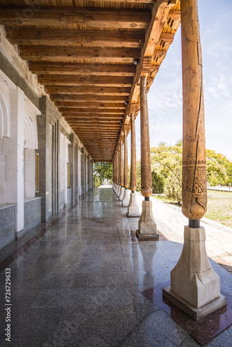 Architectural structure with wooden carved columns in Samonids Recreation Park in the ancient city of Bukhara in Uzbekistan on a warm summer sunny day photo