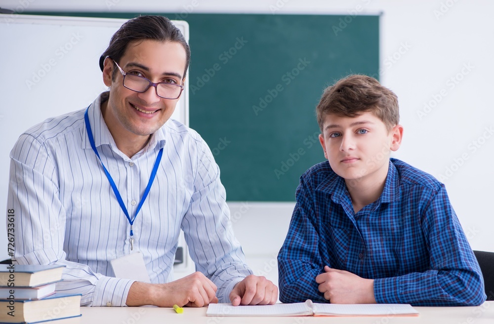 Young male teacher and boy in the classroom Young male teacher and boy in the classroom