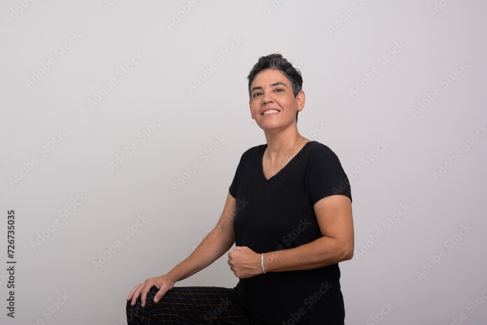 Obraz premium Beautiful short-haired woman wearing black clothes looking and smiling at the camera.