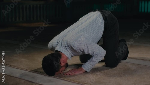 Sunni Muslim Man Going Down to Prostration in Islamic Prayer on a Mosque Carpet