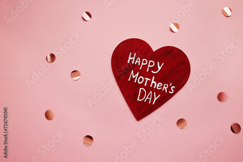 wooden red heart with white inscription happy mother's day on pink celebration background