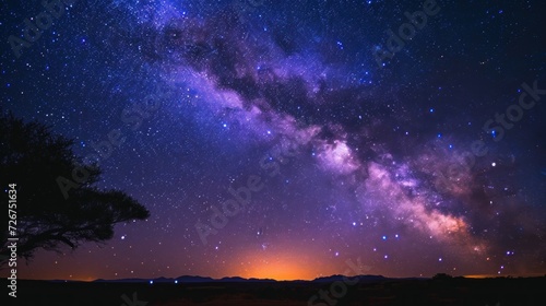  a night sky filled with stars and a silhouette of a person standing on a hill with a tree in the foreground.