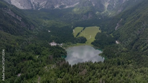 drone flying over a valley with a lake in tarviso photo