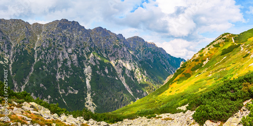 Polish Tatra Mountains, high mountain hiking trail leading to mountain peaks, mountain landscape with valleys and slopes, view on a sunny summer day.