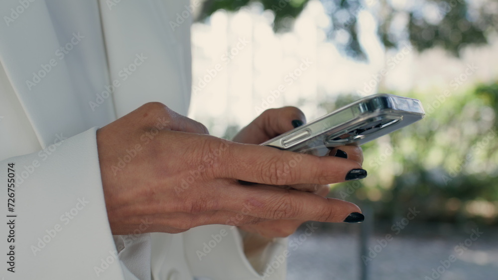 Woman hands texting smartphone outdoors close up. Unknown girl typing phone