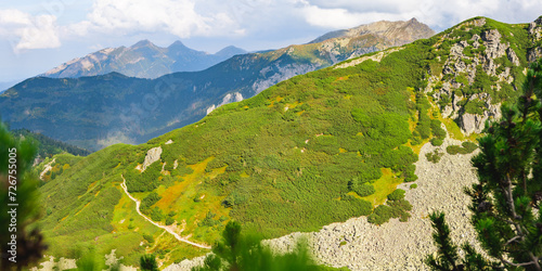 Polish Tatra Mountains, high mountain hiking trail leading to mountain peaks, mountain landscape with valleys and slopes, view on a sunny summer day.