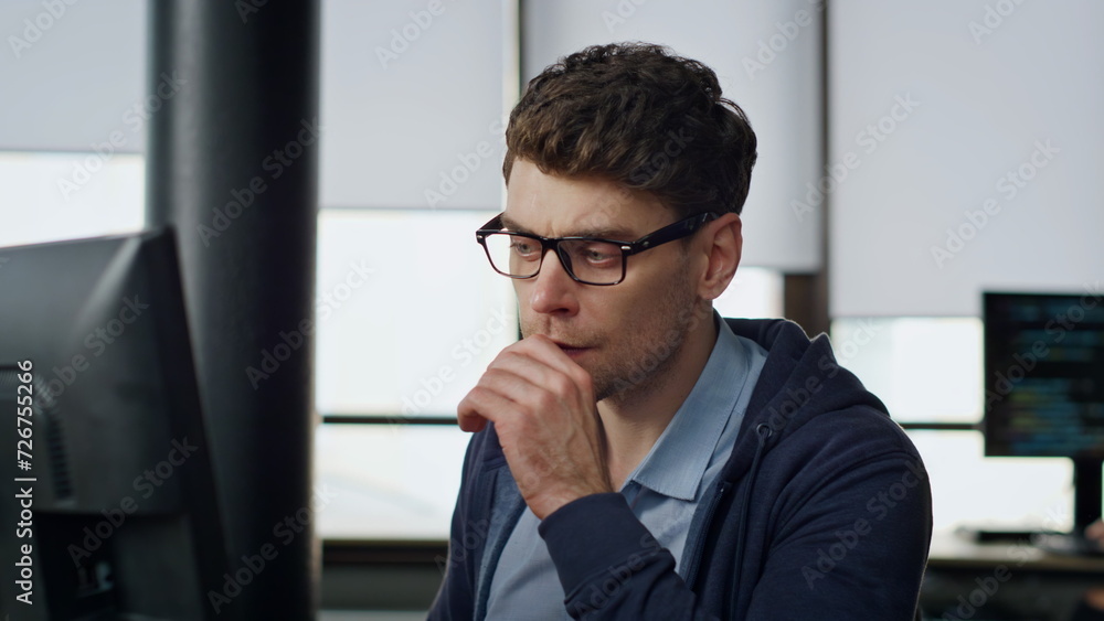 Focused manager look screen at workplace closeup. Serious programmer analyzing Focused manager look screen at workplace closeup. Serious programmer analyzing