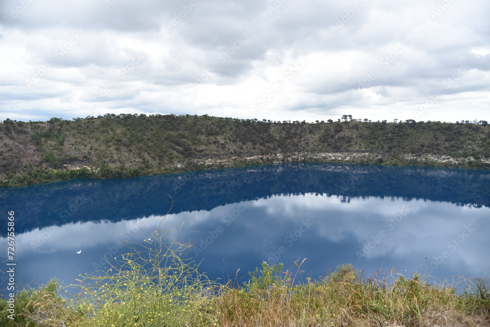The reflection from water lake with bushland at Blue Lake is a large, monomictic, crater lake located in a dormant volcanic at Mount Gambier in the Limestone Coast region of South Australia.