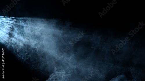 Studio shot of projector haze effect isolated on black background. Cold white colored rays shining from side with smoke.