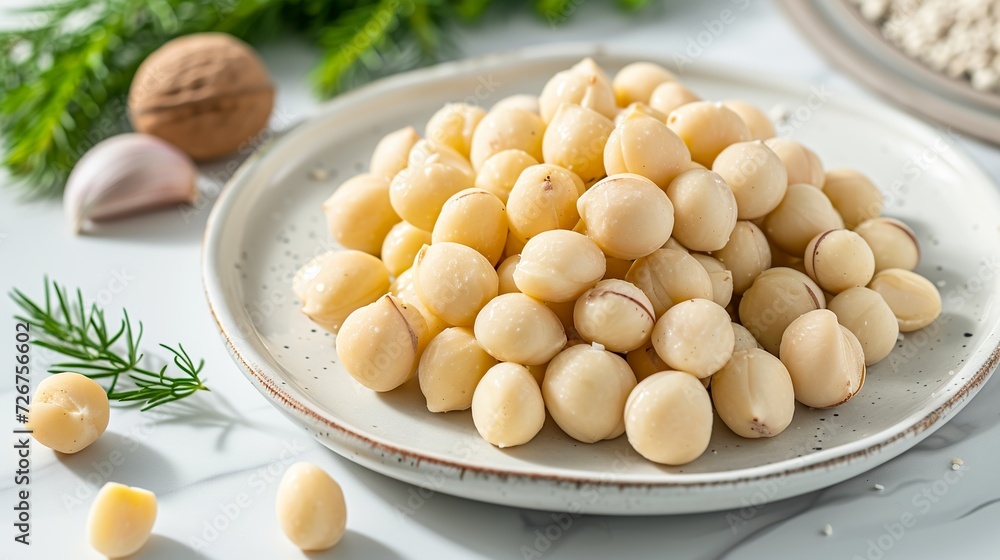 A dish of Macadamia integrifolia, a delicacy known for its premium quality. Nuts, contained in their hard shells, are prized for their crunchy texture and mild flavor. A dish of Macadamia integrifolia, a delicacy known for its premium quality. Nuts, contained in their hard shells, are prized for their crunchy texture and mild flavor.