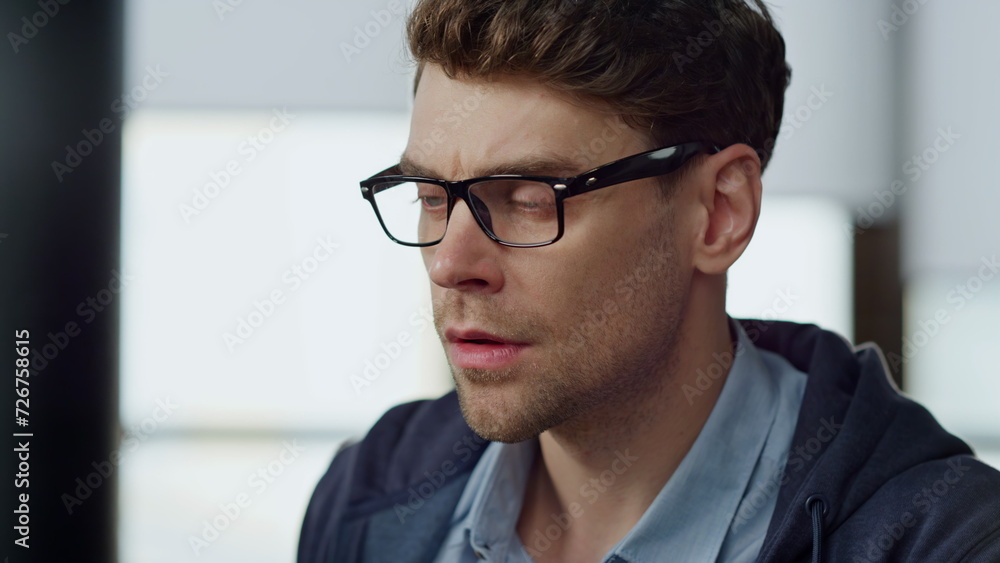 Focused it guy checking online report closeup. Pensive businessman in glasses Focused it guy checking online report closeup. Pensive businessman in glasses