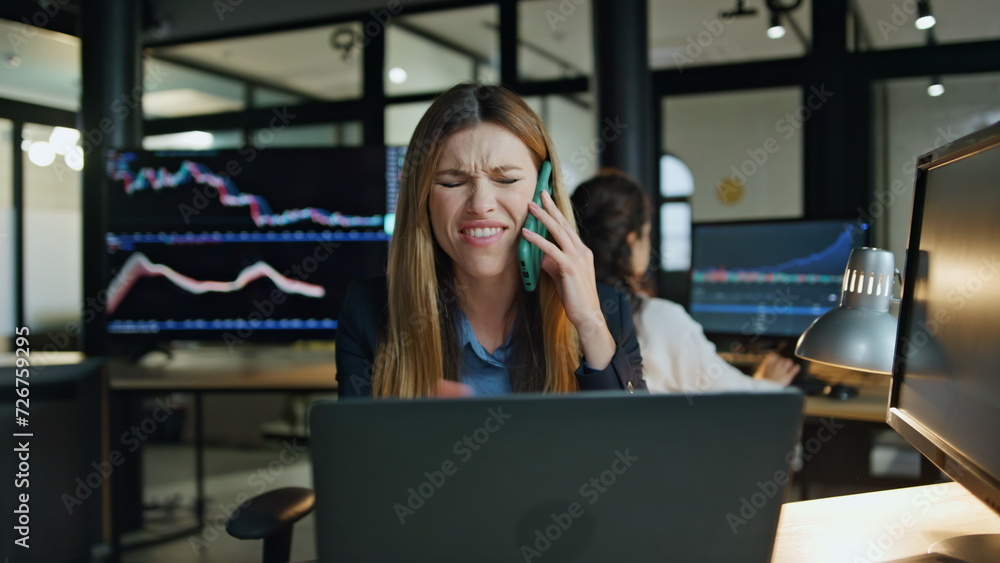 Frustrated worker talking smartphone in dark office. Unhappy businesswoman argue Frustrated worker talking smartphone in dark office. Unhappy businesswoman argue