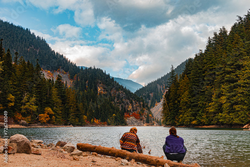 Granola Girls sitting by forest lake after hike photo