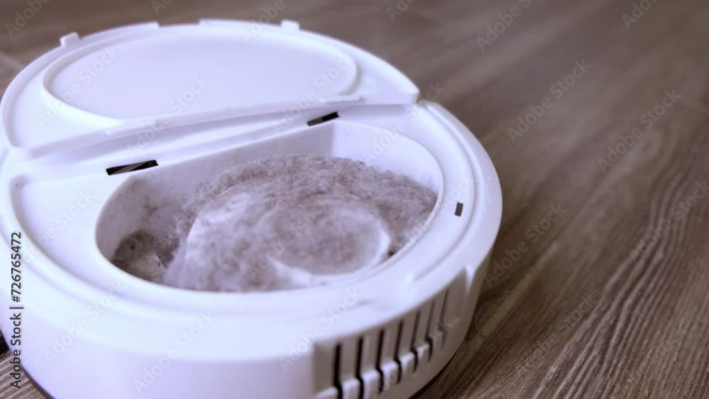 A robot vacuum cleaner removes dust in the apartment. cleaning A robot vacuum cleaner removes dust in the apartment. cleaning