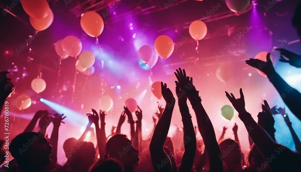 silhouette of young people having fun in a night club, colored lights, colorful balloons flying

