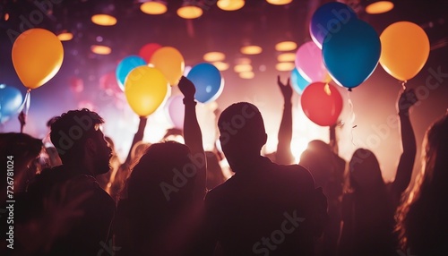 silhouette of young people having fun in a night club, colored lights, colorful balloons flying, smoky palce
