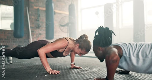 Woman, personal trainer and push ups on floor at gym for teamwork, workout or exercise together. Interracial people, coach or mentor lifting body in training, muscle gain or strength at health club photo