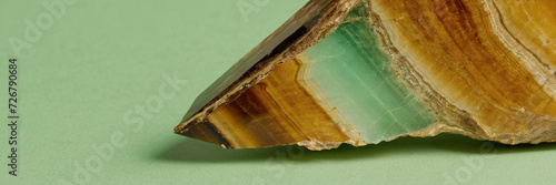 closeup macro view of unakite gemstone mineral on a pastel green background a picture for banner photo