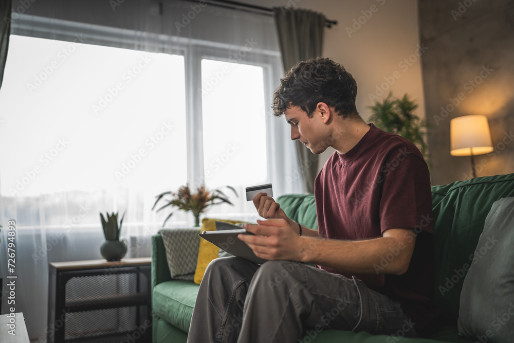 teenager young man sit at home use credit card shopping online teenager young man sit at home use credit card shopping online