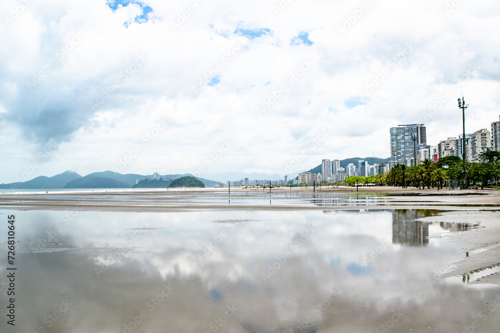 Buildings and City Skyline Reflecting in Wet Sandy Beach in Santos Brazil