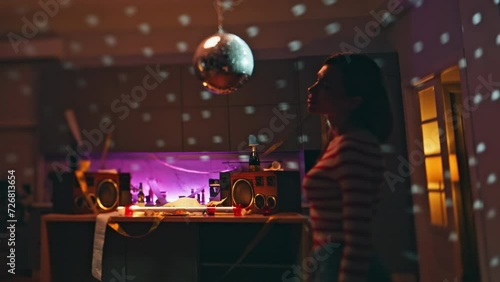 Carefree girl dancing alone after night party in apartment. Lady listening music photo