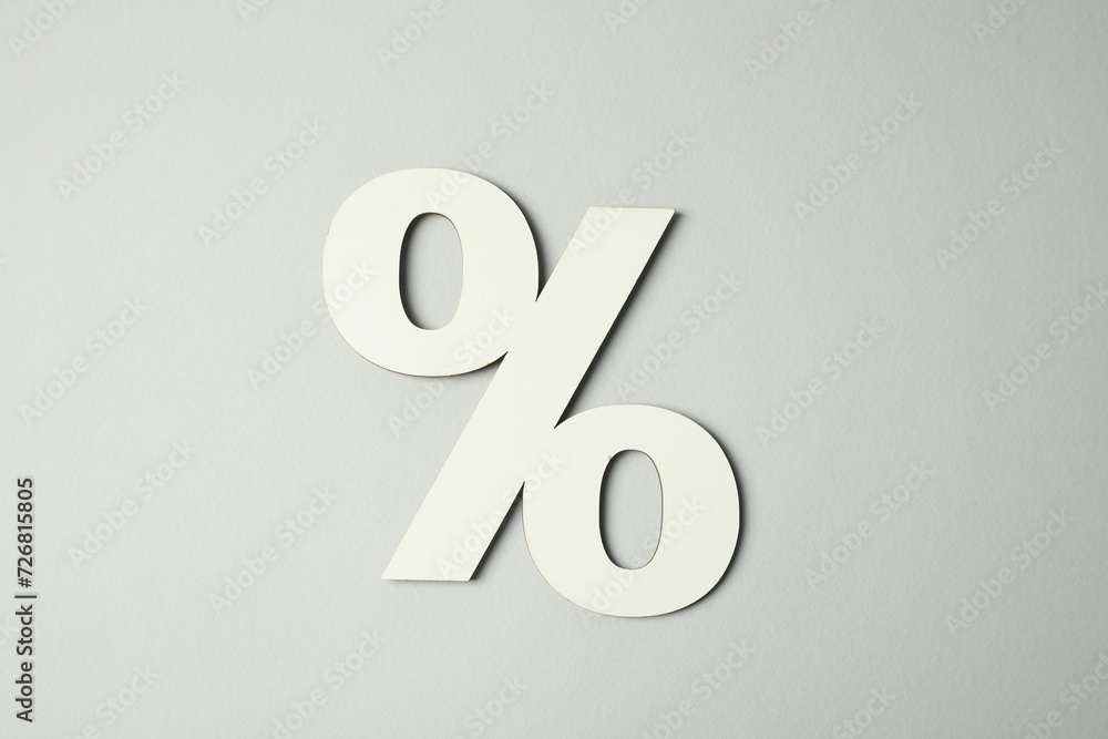 White percent sign on light grey background, top view White percent sign on light grey background, top view
