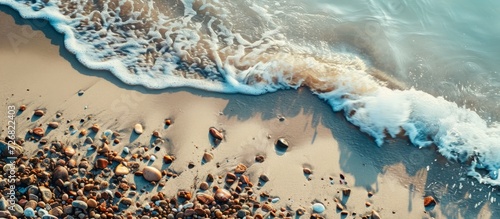 A beach is a land form next to water, made of loose particles like sand and rocks. photo