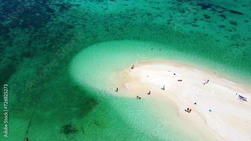 a couple of men and women at a white sandbank in the ocean of Koh Lipe Island Southern Thailand, with turqouse colored ocean and white sandy beach sandbar at Ko Lipe. photo