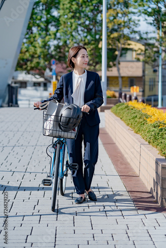 自転車で出勤するスーツを着た日本人女性