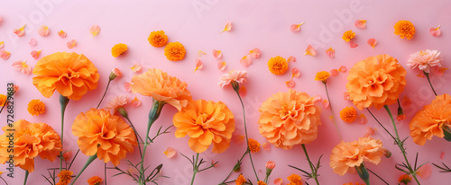 Spring marigold flowers on pink pastel background top view in flat lay style, suitable for womens or mothers day greeting or spring sale banner. photo