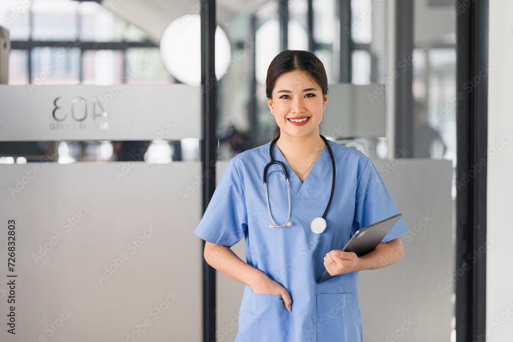 Smiling Female Doctor Holding Tablet in Hospital Lobby. Smiling Female Doctor Holding Tablet in Hospital Lobby.